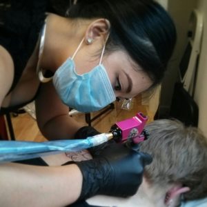 Naomi Hoang tattooing a client