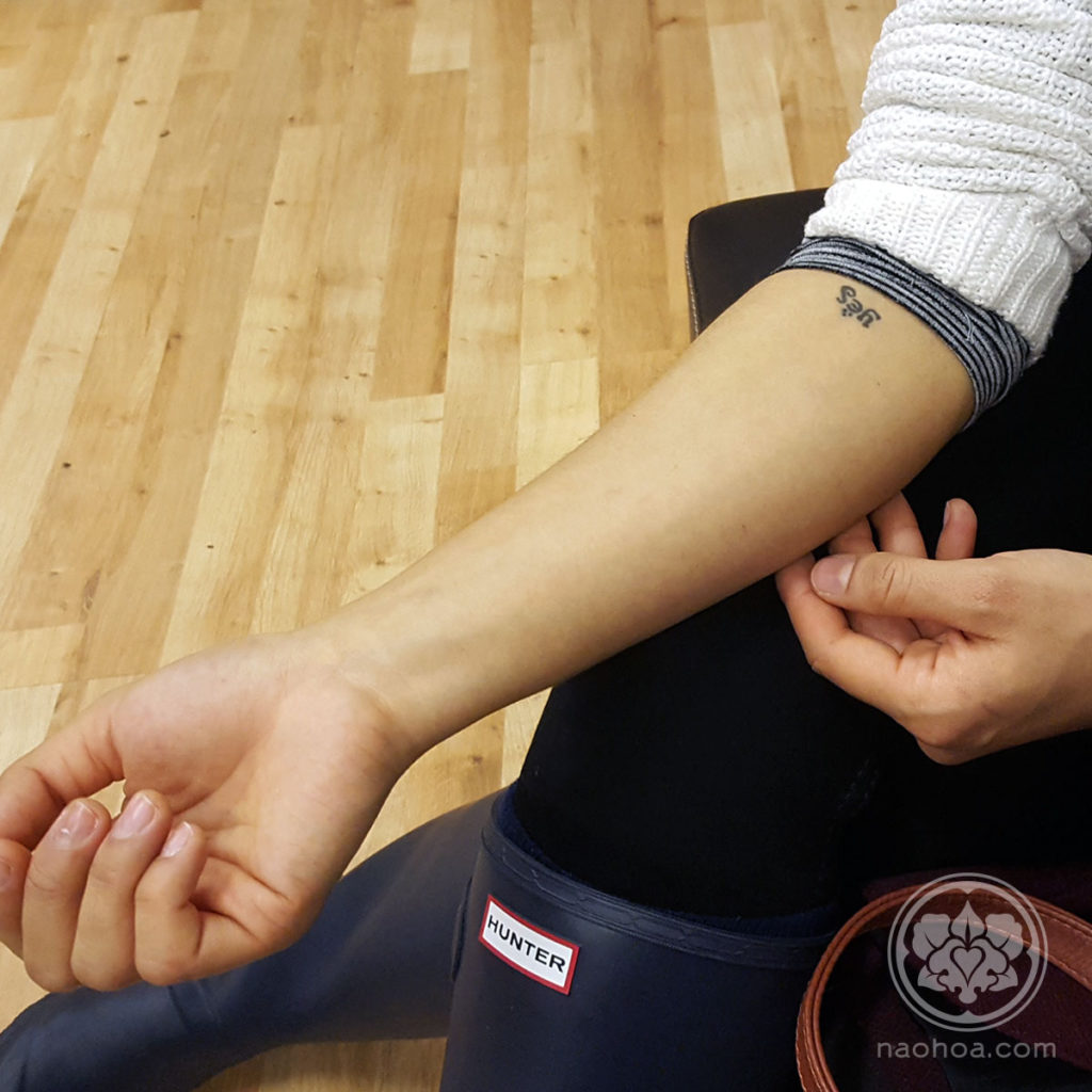 Photograph of a young woman's arm whilst sat on a sofa at NAOHOA Luxury Bespoke Tattoos, Cardiff (Wales, UK).