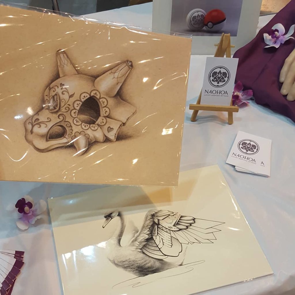 NAOHOA Luxury Bespoke Tattoos at Cardiff Comic Con, selling Sugarskull Cubone and Geo Swan Art Prints by Naomi Hoang.