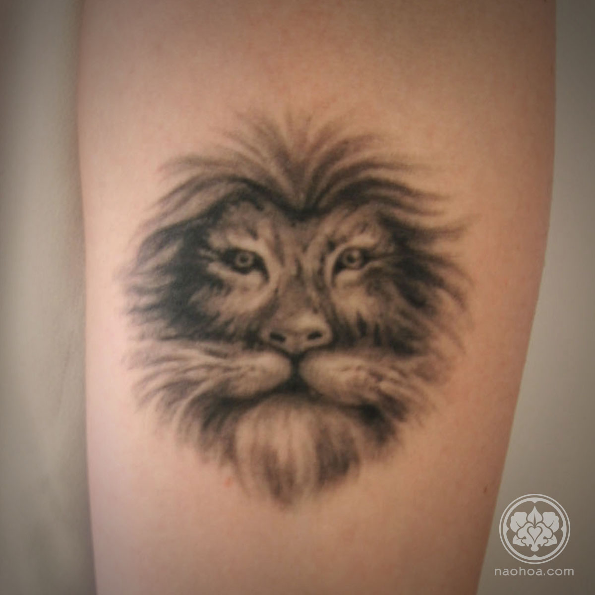 Black and white lion tattoo on a woman's inner forearm.