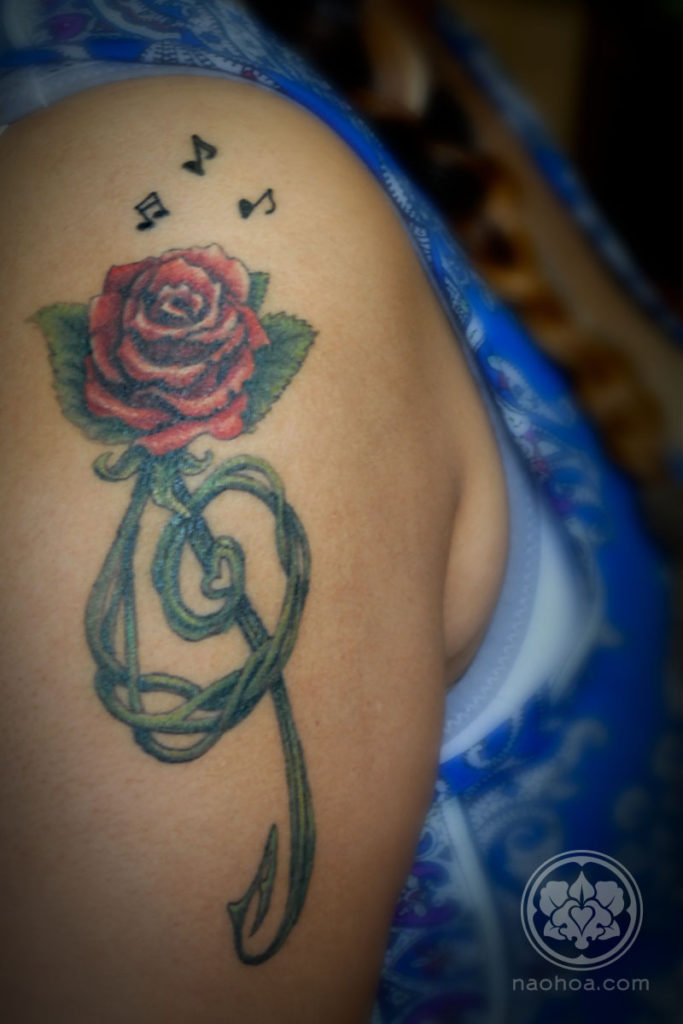 A colour tattoo of a rose shaped as a treble clef, designed and tattooed by Naomi Hoang at NAOHOA.