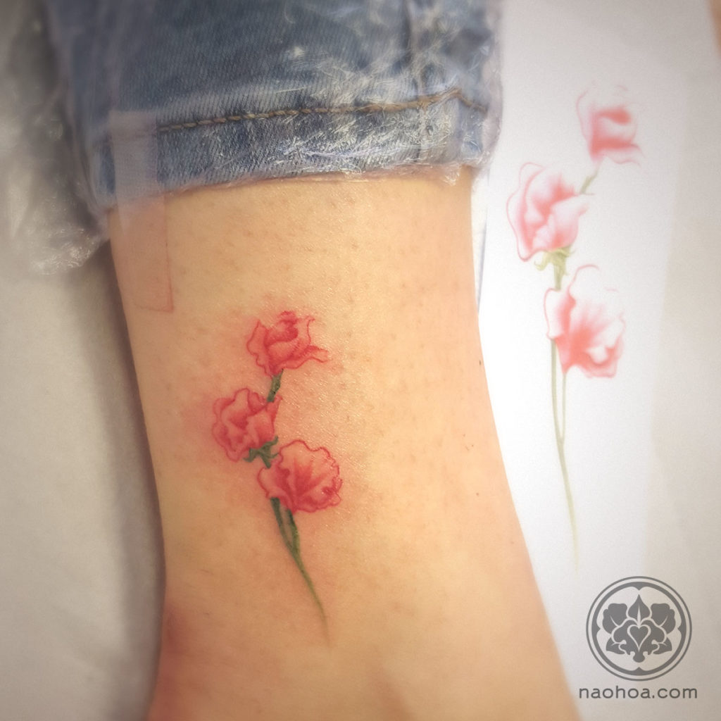 Photograph of a custom-designed tattoo of a sweetpea flower, by Naomi Hoang at NAOHOA Luxury Bespoke Tattoos, City Road, Cardiff (Wales, UK).